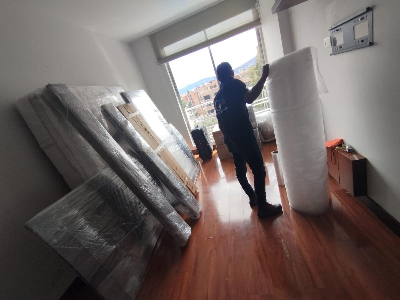 Integrante del equipo de Global Karts embalando muebles con plástico burbuja